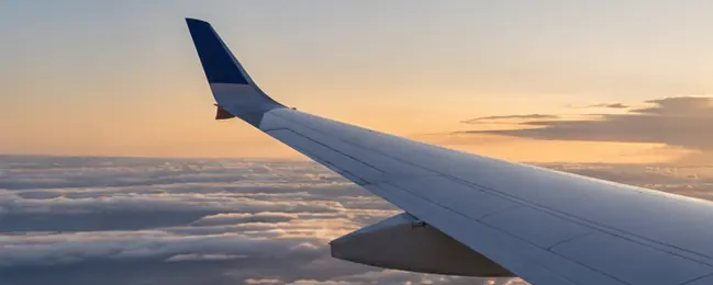 Ala de avión sobre un mar de nubes al atardecer